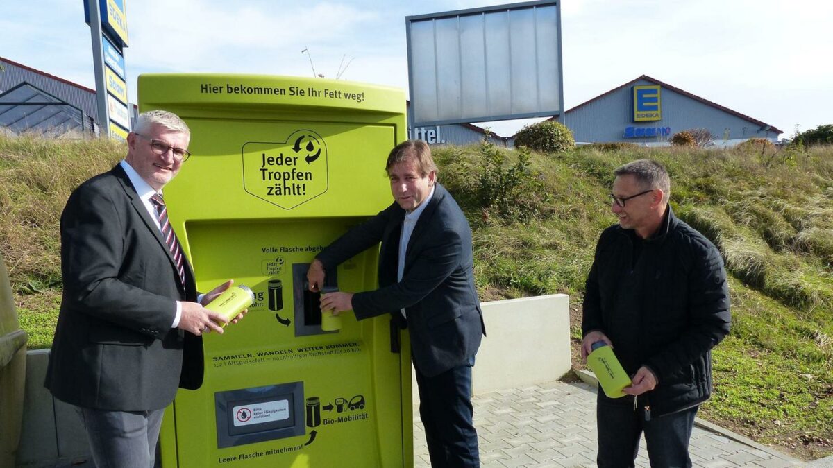 Bürgermeister Ruppert, Landrat Ulm und Hubert Zenk von „Jeder Tropfen zählt“ testen den Speisefett-Automaten. © Pauline Lindner, NNZ